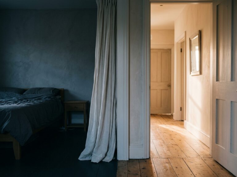 Dawn light crossing a doorway threshold between shadow and warmth